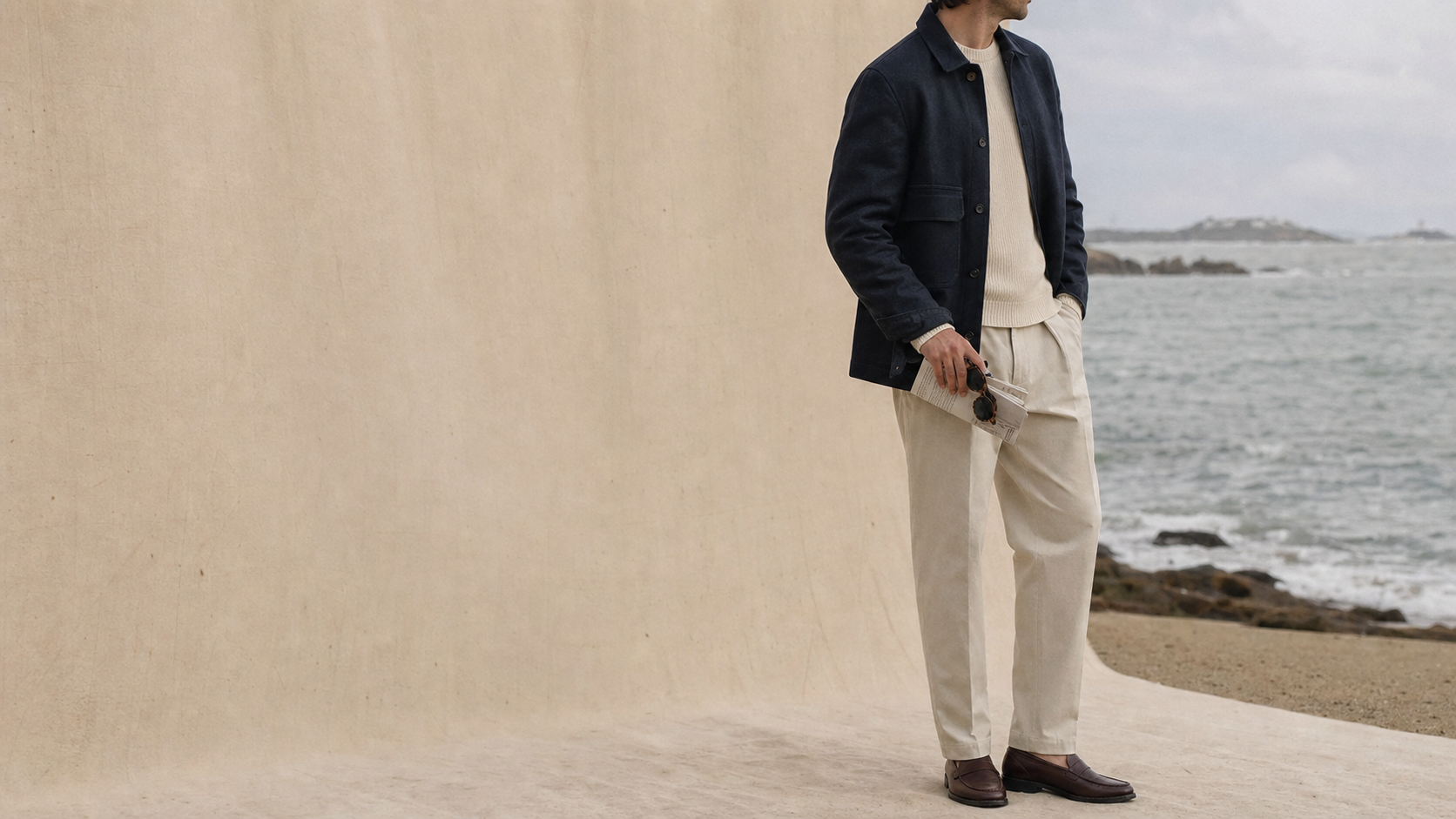 Silhouette masculine en veste marine devant la côte